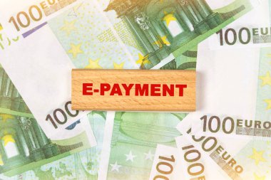 İş konsepti. Avro banknotlarının arka planında, metin ahşap bloklara - E-Ödeme