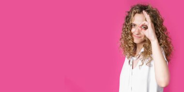 Güzel bir genç kadının portresi güzel bir jest yapar, anlaşmayı gösterir, bir fikri sever, mutlu bir şekilde gülümser, içeride modellik yapar. Teşekkür ederim. El işareti