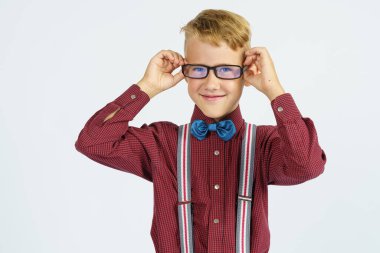 Gözlüğünü ayarlayan bir okul çocuğunun portresi. Eğitim kavramı.