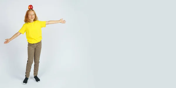 Teenage Girl Yellow Shirt Holds Apple Her Head Isolated Background — Stock Photo, Image
