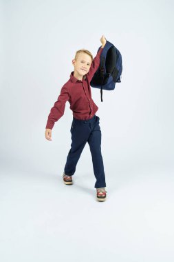 Bir okul çocuğu okul çantasını kaldırıyor. Eğitim kavramı