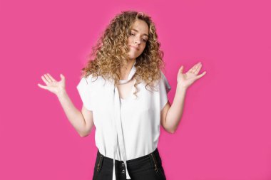 Genç kadın ellerini havaya kaldırdı. Pembe arka planda izole edilmiş