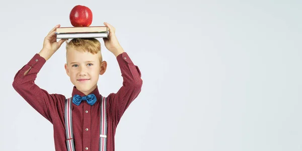 Een Schooljongen Houdt Boeken Met Een Appel Zijn Hoofd Glimlacht — Stockfoto