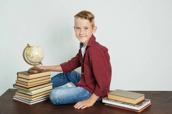 Estudante Senta Uma Mesa Perto Livros Segura Globo Com Mão — Fotografia de Stock