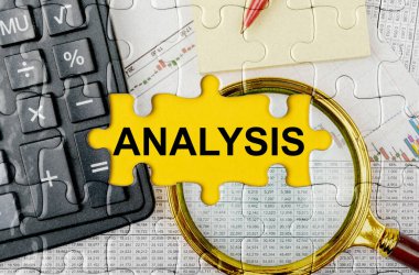 İş konsepti. Hesap makinesi, büyüteç ve mali dökümanlarla dolu bir bulmaca - ANALYSIS
