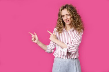 Neşeli bir kadın fotokopi odasını işaret eder, harika bir ilandan bahseder, yol verir ya da yön verir, çizgili bir gömlek giyer, hoş bir gülümsemesi vardır ve iyimser hisseder. Pembe arka planda izole edilmiş