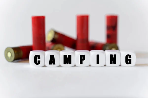 在来复枪子弹的背景下 有白色立方体与文字Camping 狩猎和危险概念 — 图库照片