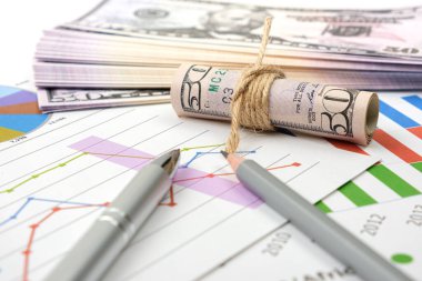 İş hedefi kavramı. İş aksesuarı, grafik çizelgeleri, kalem ve dolar masanın üzerinde..