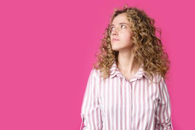 Genç ve güzel bir kadın boş fotokopi odasına bakarak düşünüyor. İzole edilmiş pembe arkaplan