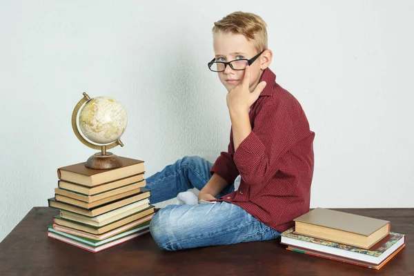 Uno Scolaro Siede Tavolo Vicino Libri Globo Raddrizza Suoi Occhiali — Foto Stock