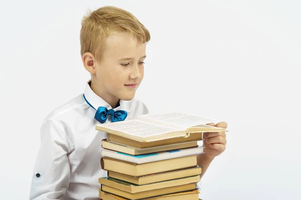 Een Schooljongen Zit Bij Een Stapel Boeken Leest Geïsoleerde Achtergrond — Stockfoto