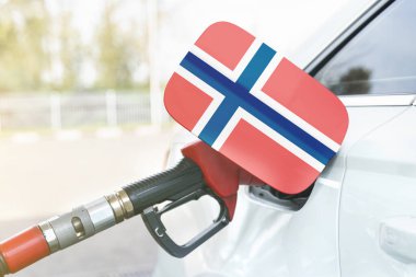 Enerji ve ekonomi kavramı. Arabanın benzin deposunda Norveç bayrağı var. Depoda da benzin pompası var..