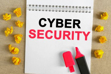 İş konsepti. Metin defterde yazılı - CYBER GÜVENLİĞİ. Defterin üzerinde bir işaret var, yanında buruşuk sarı kağıt var..