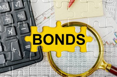 İş konsepti. Hesap makinesi, büyüteç ve mali belgelerle dolu bir bulmaca - BONDS