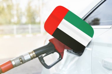 Enerji ve ekonomi kavramı. Arabanın benzin deposunda Birleşik Arap Emirlikleri bayrağı var. Depoda da benzin pompası var..