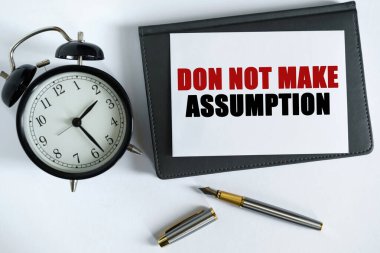 İş ve olumlu kavram. Masanın üzerinde bir saat, bir kalem, bir defter ve üzerine metin yazılan bir kart var.