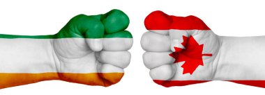 İnsanların mücadelesi kavramı. İki el birbirine kenetlenir ve birbirlerinin karşısındadır. Ülkelerin bayraklarının renklerine boyanmış eller. Kanada, Cote Divoire 'a Karşı