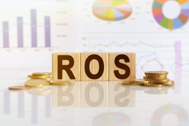 Satışta Dönüş. Tahta küplerle ilgili bir kelime, yansıtıcı bir yüzey üzerinde duran küpler, arka planda bir iş diyagramı var. İş ve finans kavramı