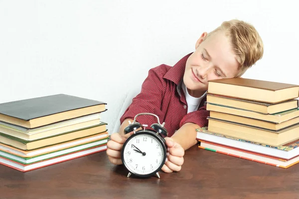 Oktatási Koncepció Tanuló Egy Asztalnál Könyvekkel Egy Ébresztőórát Tart Kezében — Stock Fotó
