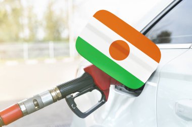Enerji ve ekonomi kavramı. Arabanın benzin deposunda Nijer bayrağı var. Depoda da benzin pompası var..