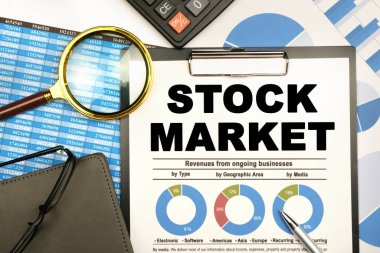 Finans ve iş konsepti. İş adamının masasında raporlar, bir defter, bir büyüteç ve üzerinde 