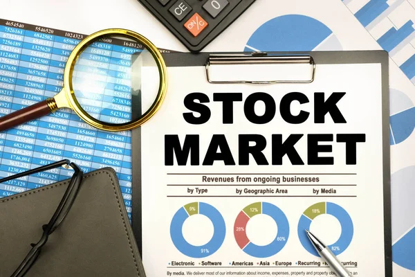 Finans ve iş konsepti. İş adamının masasında raporlar, bir defter, bir büyüteç ve üzerinde 