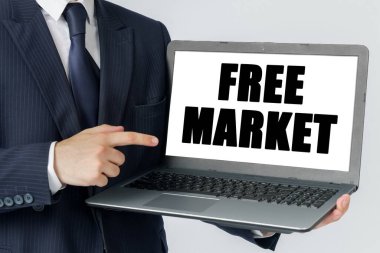 Finans ve ekonomi kavramı. Bir iş adamı dizüstü bilgisayarını elinde tutuyor ve ekranda şu metni gösteriyor: Özgür MARKET