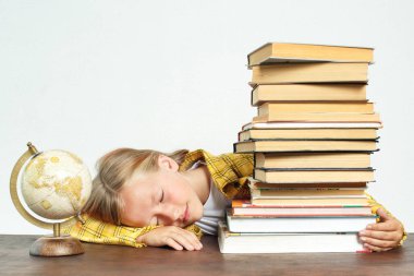 Eğitim konsepti. Öğrenci ev ödevini yaparken uyuyakaldı. Kitapların ve kürenin yanında.