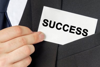 İş konsepti. İş adamının elinde metnin olduğu bir kart var - SUCCESS