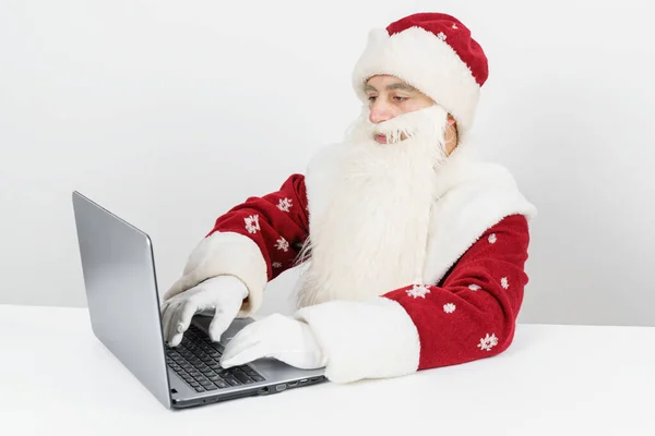크리스마스와 컨셉이야 산타클로스는 책상에 앉아서 컴퓨터로 — 스톡 사진