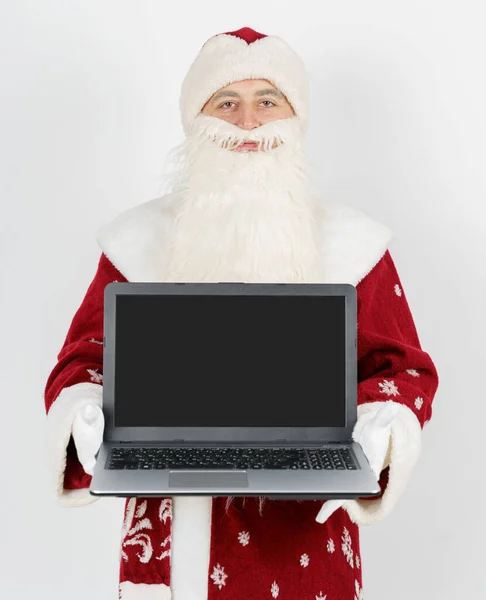 クリスマスと新年のコンセプト サンタクロースは彼の机に座ってコンピュータで仕事をしています — ストック写真