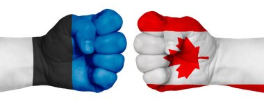 İnsanların mücadelesi kavramı. İki el birbirine kenetlenir ve birbirlerinin karşısındadır. Ülkelerin bayraklarının renklerine boyanmış eller. Kanada - Estonya