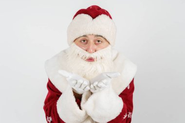 Noel ve Yeni Yıl konsepti. Noel Baba avuç içini uçurur. İzole edilmiş arkaplan.