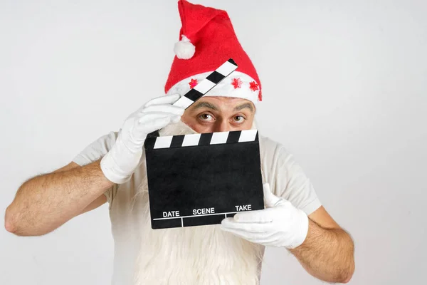圣诞节和新年的概念 圣诞老人在影片的片场上与一块板一起工作 孤立的背景 — 图库照片