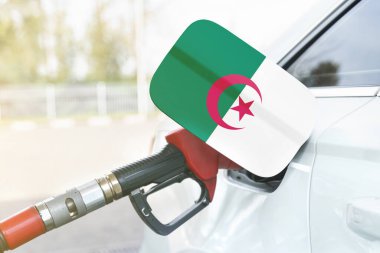 Enerji ve ekonomi kavramı. Arabanın yakıt deposunda Cezayir bayrağı var. Depoda da benzin pompası var..