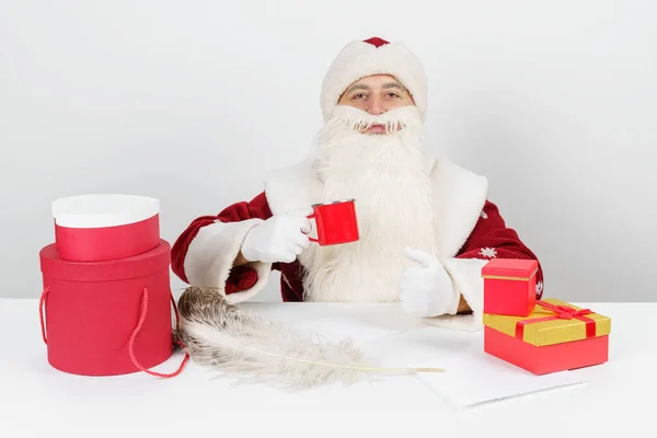 Conceito Natal Ano Novo Papai Noel Senta Sua Mesa Bebe — Fotografia de Stock