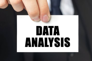 İş konsepti. İş adamı üzerinde DATA ANALYSIS yazan bir kart gösteriyor