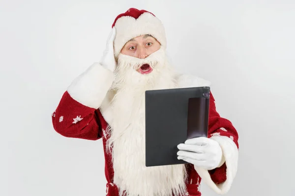 Kerstmis Nieuwjaar Concept Kerstman Leest Een Brief Een Tablet Verbaasd — Stockfoto