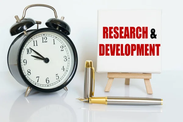 비즈니스 위에는 시계가 있으며 위에는 문자가 쓰여져 카드가 Research Development — 스톡 사진