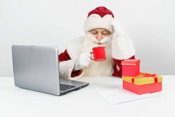 Concepto Navidad Año Nuevo Santa Claus Está Sentado Escritorio Bebiendo —  Fotos de Stock