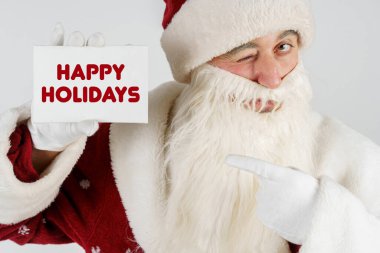 Yeni yıl ve Noel konsepti. Noel Baba 'nın elinde bir kart var - Mutlu Noeller.