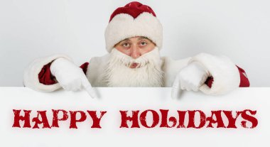 Yeni yıl ve Noel konsepti. Noel Baba parmaklarıyla tahtayı işaret ediyor - Mutlu bayramlar