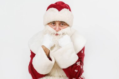 Yeni yıl konsepti. Noel Baba kafası ellerinin arasında oturur. Beyazda izole edilmiş