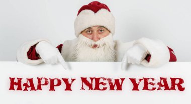 Yeni yıl ve Noel konsepti. Noel Baba parmaklarıyla tahtayı işaret ediyor - Mutlu Yıllar