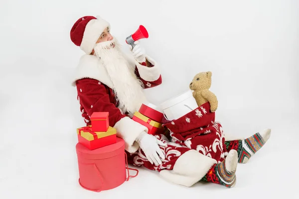 Koncepcja Noworoczna Świąteczna Święty Mikołaj Siedzi Wśród Darów Mówi Megafonu — Zdjęcie stockowe
