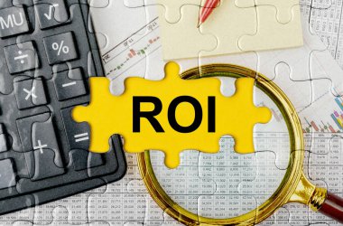 İş konsepti. Hesap makinesi, büyüteç ve mali belgelerle dolu bir bulmaca - ROI