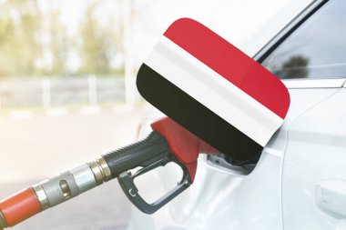 Enerji ve ekonomi kavramı. Arabanın benzin deposunda Yemen bayrağı var. Depoda da benzin pompası var..