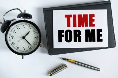 İş ve olumlu kavram. Masanın üzerinde bir saat, bir kalem, bir defter ve üzerine yazı yazılmış bir kart var.