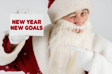 Yeni yıl ve Noel konsepti. Noel Baba elinde metin olan bir kart tutuyor - Yeni Yıl Hedefleri