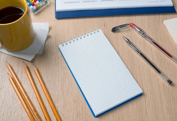 Notepad, pens and pencils on the writing desk